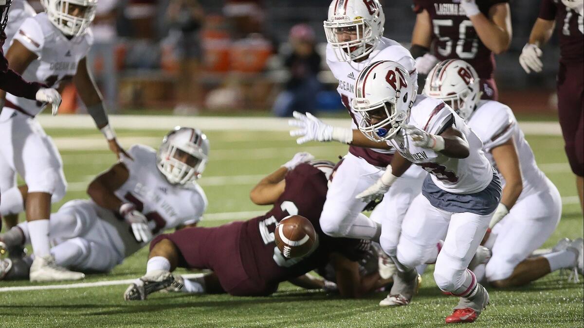 Ocean View High's Raelen Bruce, right, pictured trying to get his hands on a fumble at Laguna Beach on Oct. 19, will look to keep the Seahawks' Pac 4 League championship hopes alive on Thursday.