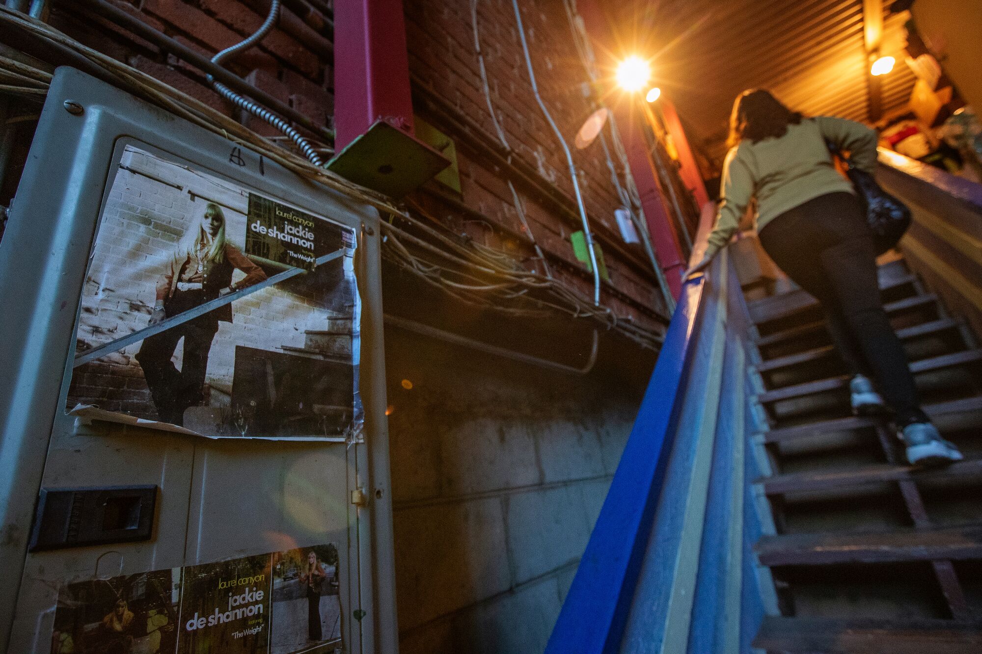 A poster of singer Jackie DeShannon hangs on the wall above a flight of stairs.