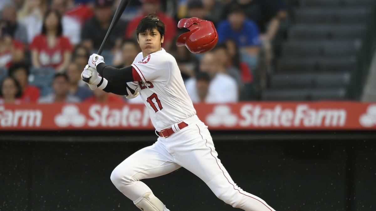Angels designated hitter Shohei Ohtani loses his helmet while swinging at a pitch during the first inning of a 9-6 victory over the Houston Astros on Monday.