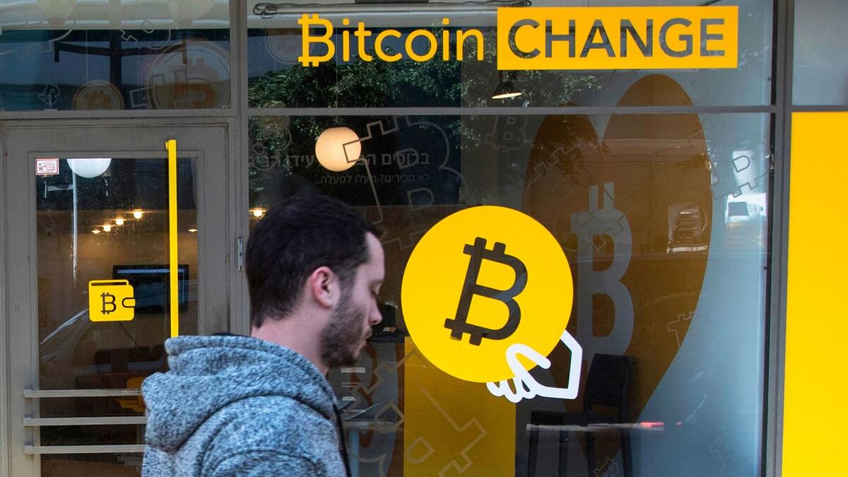 A man walks past the Bitcoin Change cryptocurrency shop in Tel Aviv, Israel.