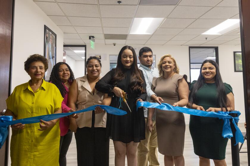 Employees participate in the ribbon-cutting ceremony for the new office of the Honduran Consulate 