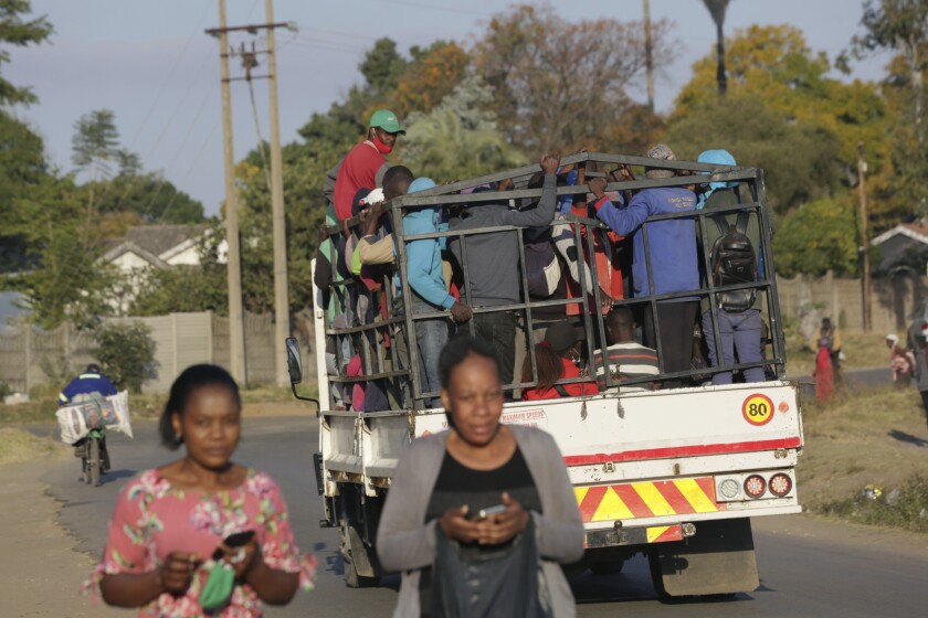 A truck loaded with people travels on a street, in Harare, Tuesday, July, 6, 2021. Zimbabwe has reactivated strict lockdown measures it once imposed when COVID-19 first hit the country last year, as the country battles a resurgence of the virus amid vaccine shortages. (AP Photo/Tsvangirayi Mukwazhi)