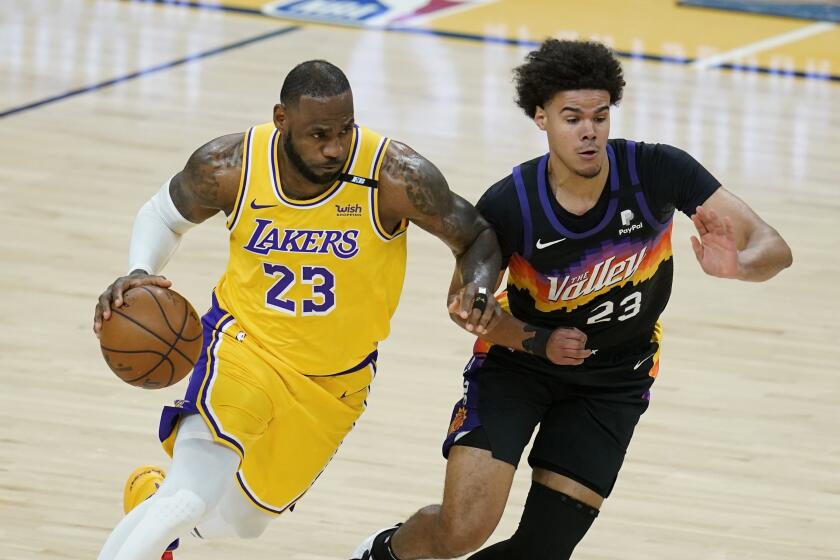 Los Angeles Lakers forward LeBron James (23) dribbles past Phoenix Suns forward Cameron Johnson, right, during the first half of Game 2 of their NBA basketball first-round playoff series Tuesday, May 25, 2021, in Phoenix. (AP Photo/Ross D. Franklin)