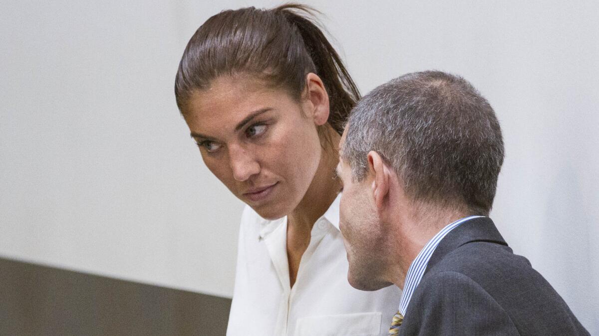 U.S. women's soccer team goalkeeper Hope Solo listens to her attorney, Todd Maybrown, while appearing in court in Kirkland, Wash., on Monday.