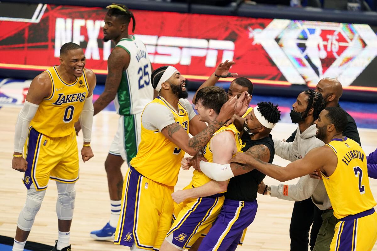 Lakers guard Austin Reaves, center, celebrates with teammates after the Lakers' 107-104 overtime victory.