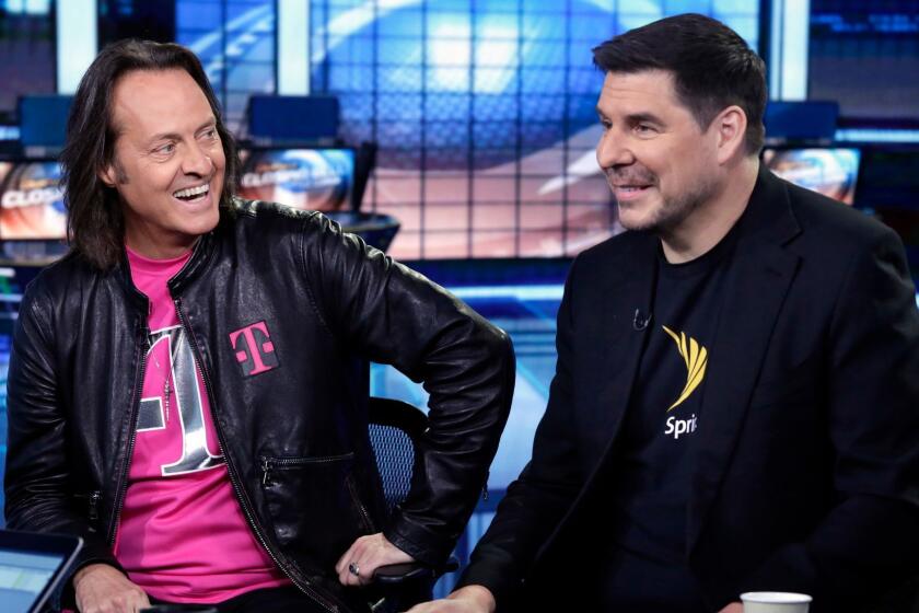 T-Mobile CEO John Legere, left, and Sprint CEO Marcelo Claure are interviewed by Liz Claman during her "Countdown to the Closing Bell" program on the Fox Business Network, in New York, Monday, April 30, 2018. To gain approval for their $26.5 billion merger agreement, T-Mobile and Sprint aim to convince antitrust regulators that there is plenty of competition for wireless service beyond Verizon and AT&T. (AP Photo/Richard Drew)