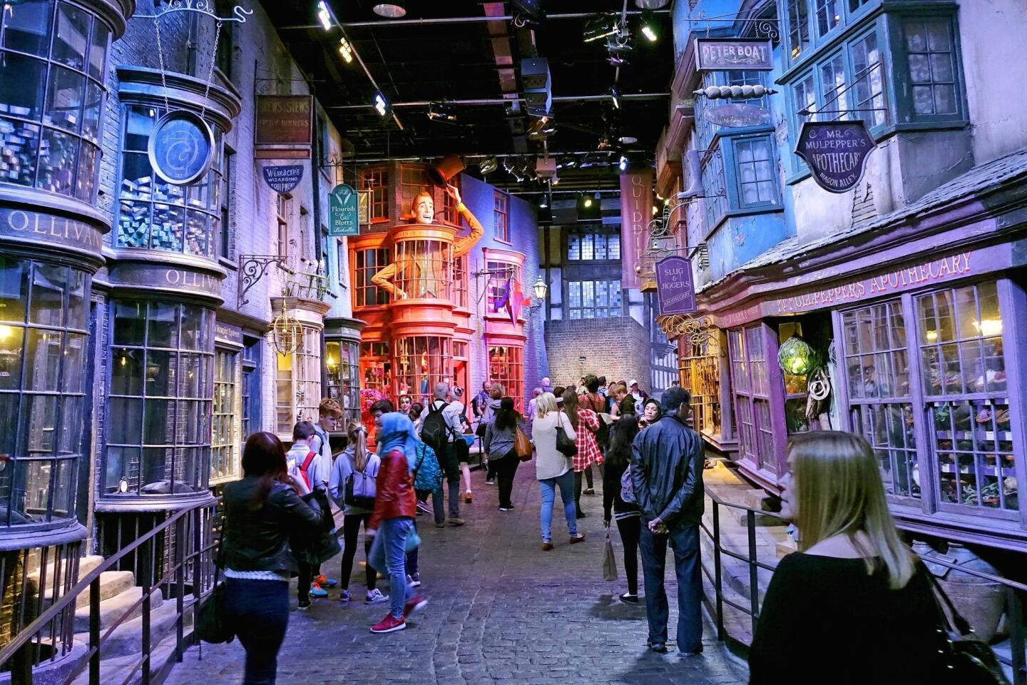 Tourists stroll along the Diagon Alley movie set at The Making of Harry Potter Warner Bros. Studios experience in London.