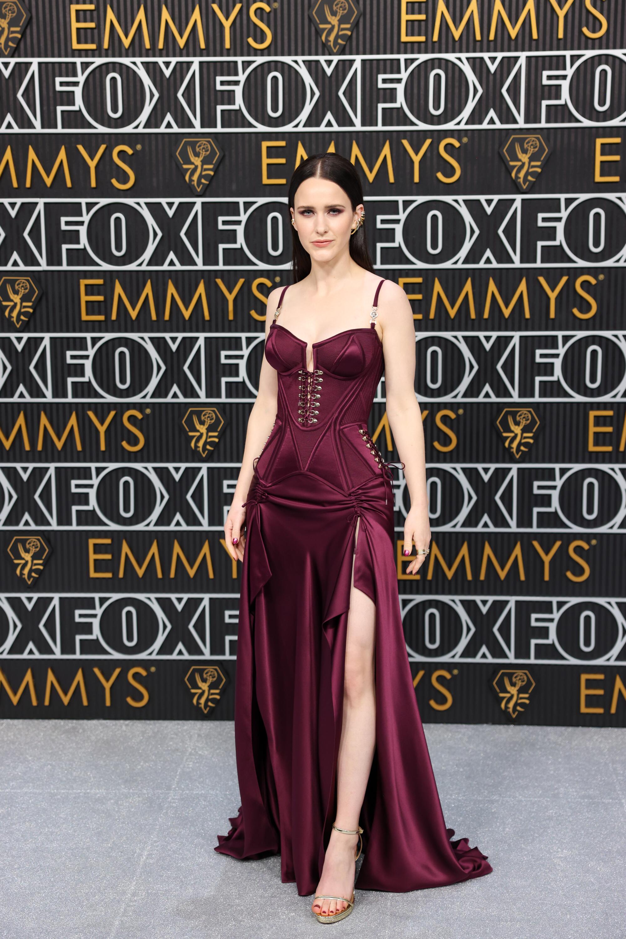 Rachel Brosnahan wears a plum-colored dress on the Emmys red carpet.  