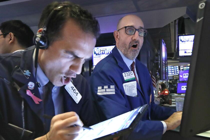 Trader Gregory Rowe, left, and specialist Peter Giacchi work on the floor of the New York Stock Exchange on Thursday.