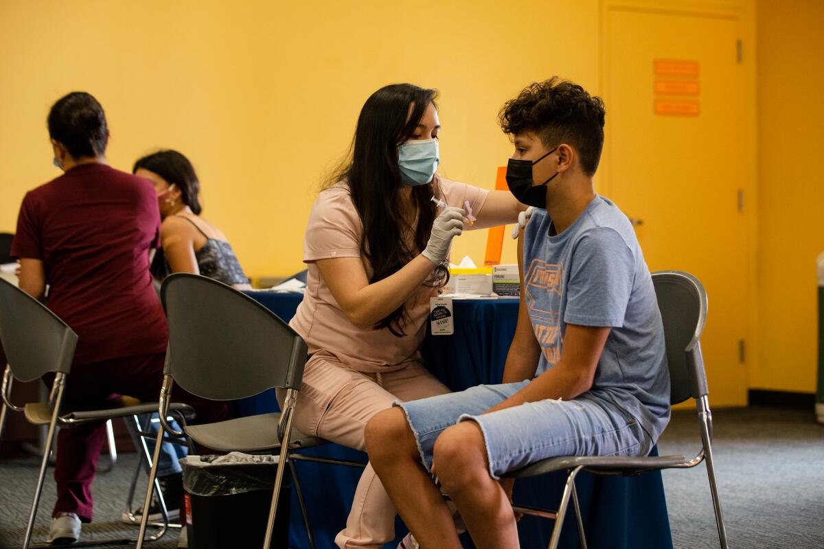 Jorge Olvera, 13, and his sister Mariana Olvera, 12, receive COVID-19 vaccines at pop-up vaccination site at SeaWorld.