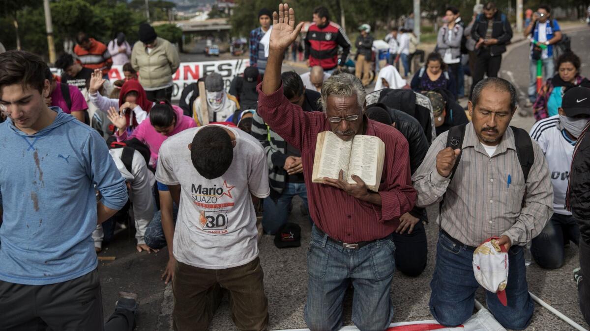 Supporters of presidential candidate Salvador Nasralla kneel in prayer during a protest outside the National Institute of Professional Training, where election ballots are stored.