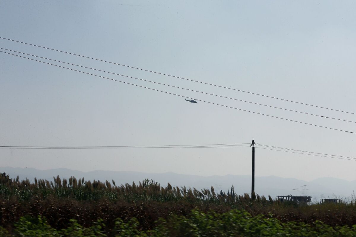 A Russian-made helicopter hovers over the airport in Latakia, Syria, on Sept. 24.