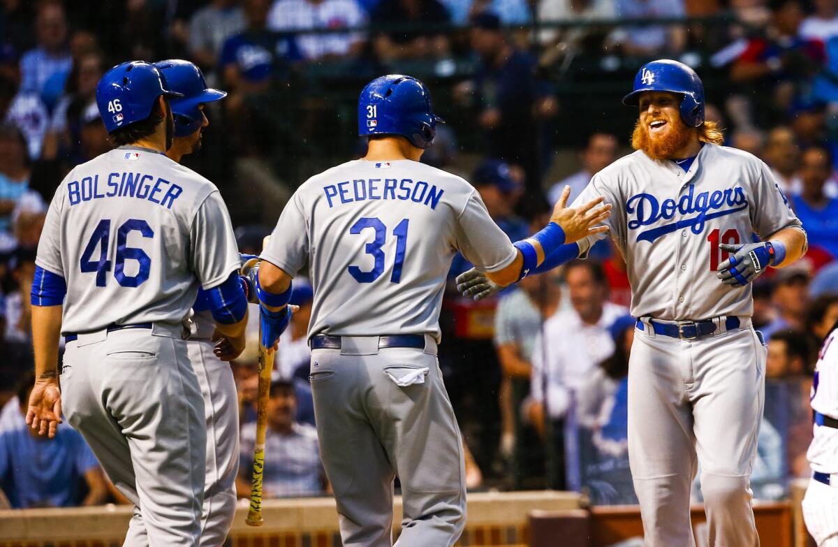Dodgers third baseman Justin Turner celebrates with Joc Pederson (31) and Mike Bolsinger (46) after driving them in with a three-run home run against the Chicago Cubs on Wednesday at Wrigley Field.