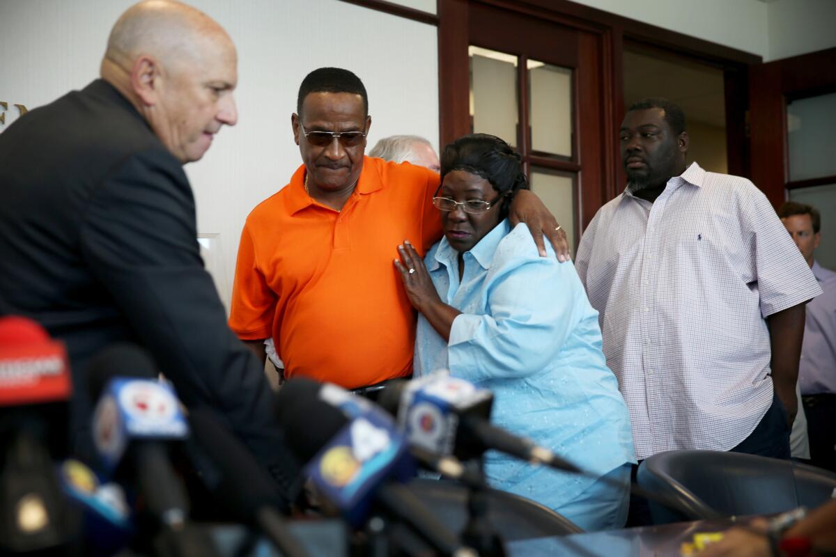 Catherine Daniels, the mother of Lavall Hall, is hugged by her cousin Alfonzo Hill at her attorney's Miami office on Wednesday. Video released by the family shows the moments during which Miami Gardens police fatally shot Hall, who was mentally ill.