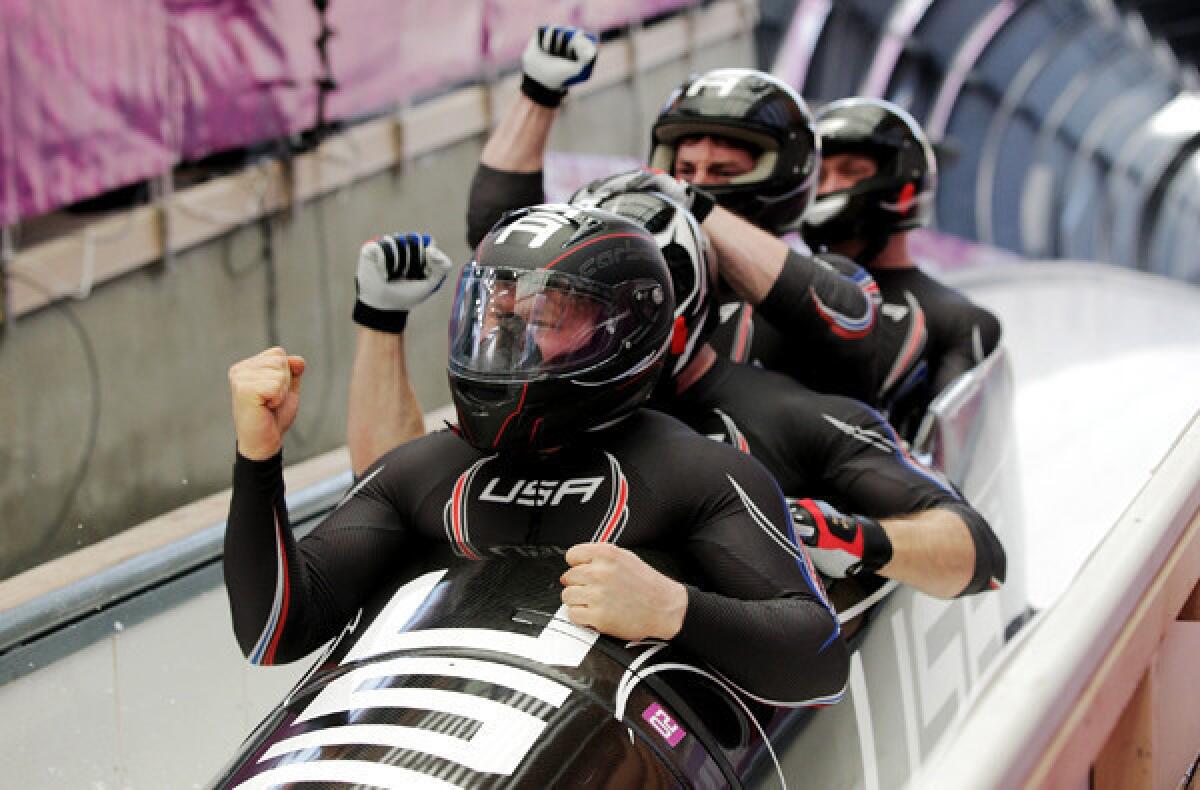 USA 1 bobsled team members -- pilot Steven Holcomb, Curtis Tomasevicz, Steven Langton and Christopher Fogt -- react when they see their final-run time on Sunday at the Sliding Center Sanki.