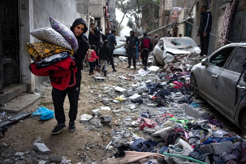 I palestinesi guardano alla distruzione dopo un attacco aereo israeliano a Rafah, nella Striscia di Gaza, venerdì 9 febbraio 2024. (AP Photo/Fatima Shbair)