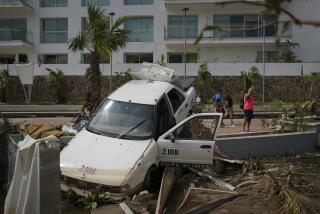 A damaged car lays on a street divider after Hurricane Otis ripped through Acapulco, Mexico, Thursday, Oct. 26, 2023. The hurricane that strengthened swiftly before slamming into the coast early Wednesday as a Category 5 storm has killed at least 27 people as it devastated Mexico’s resort city of Acapulco. (AP Photo/Felix Marquez)