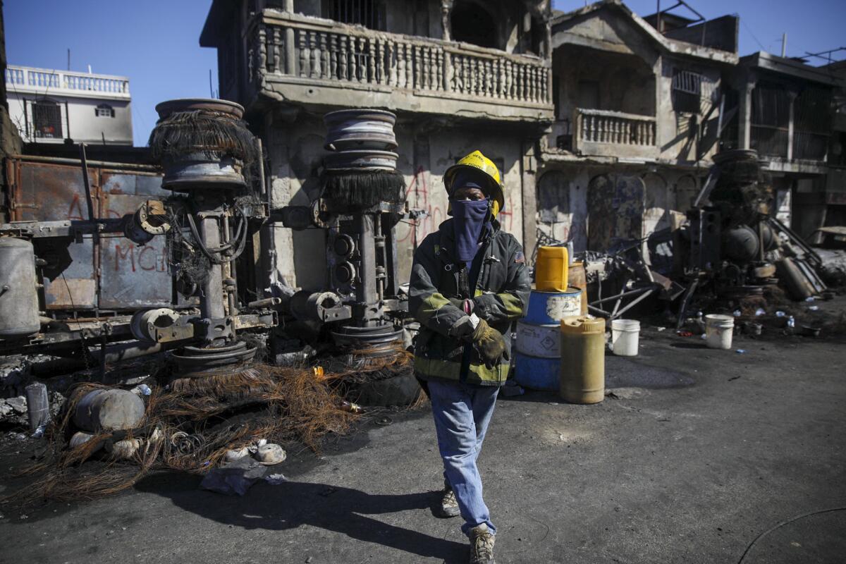 Firefighter standing next to overturned and burned-out truck