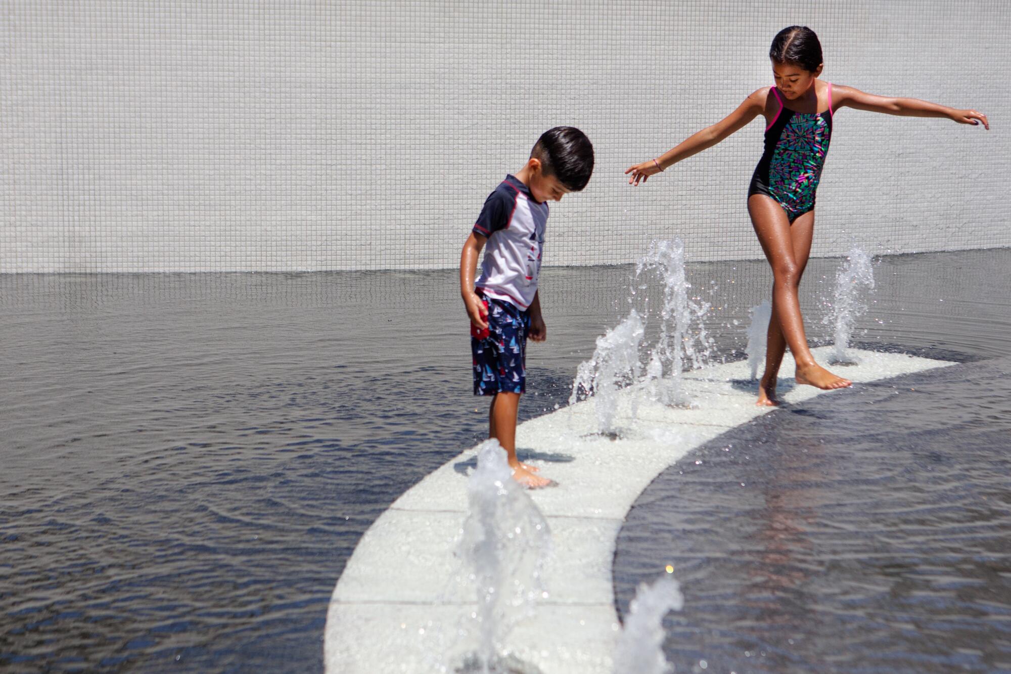Zoe Valdez, 8, right, and Thiago Valdez, 4, of East Los Angeles play in the Grand Park fountain on Aug. 2.