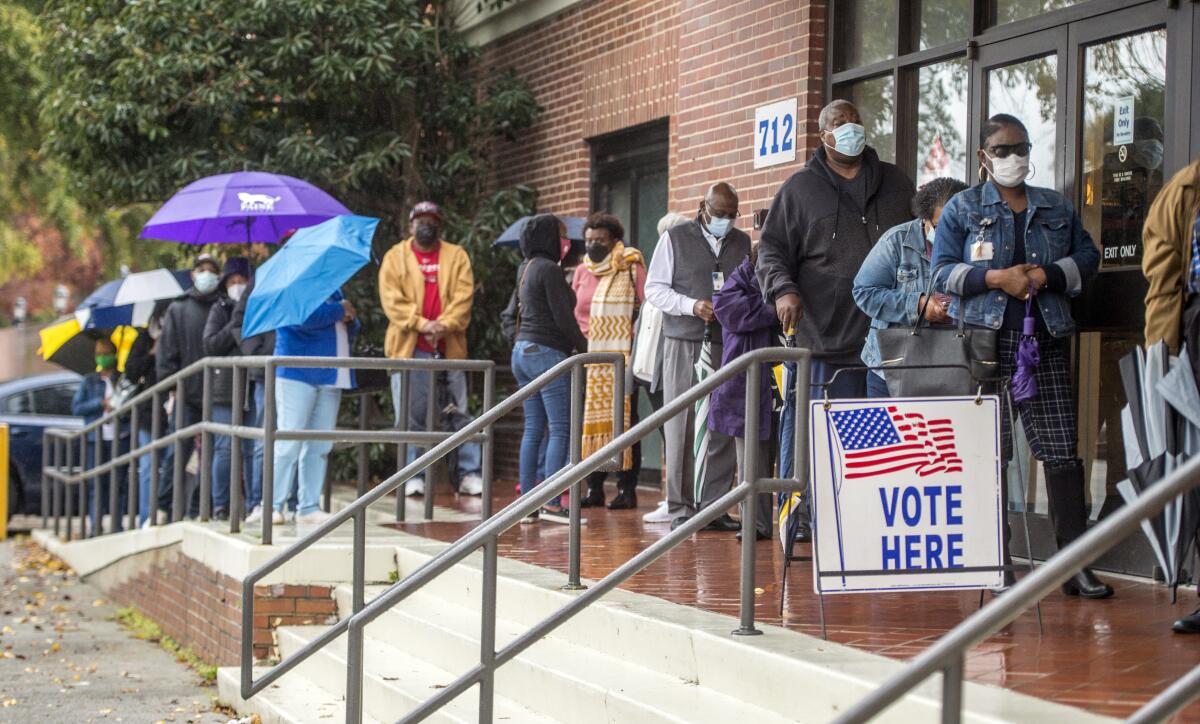 People wait in line on the first day of advance voting for Georgia's Senate runoff election