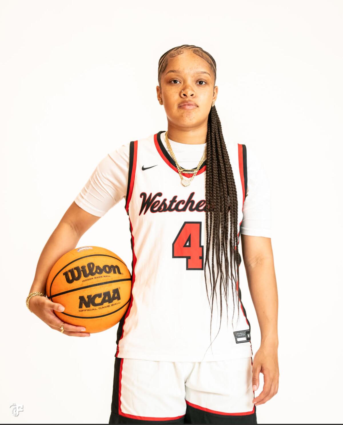 Savannah Myles of Westchester High poses for a photo in uniform with a basketball tucked under her right arm.