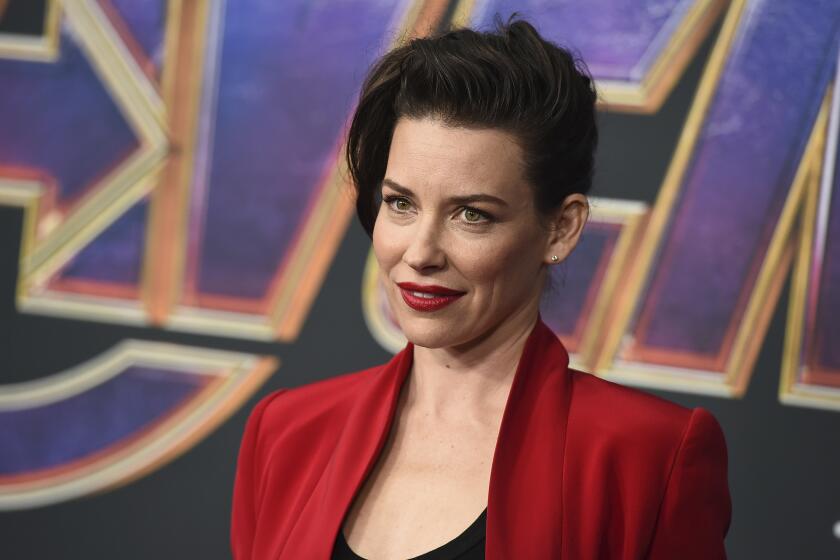 A woman in a red suit at a movie premiere