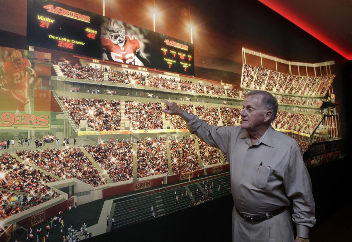 Retired 49ers General Manager John McVay shows off where he would like to sit at the planned new home of the 49ers at the Preview Center in Santa Clara on Sept. 27, 2011.