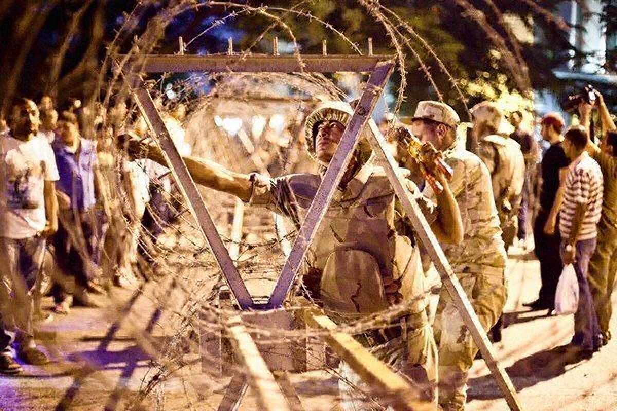 Egyptian soldiers move barbed wire surrounding the Supreme Constitutional Court in Cairo ahead of planned demonstrations. The heavy presence of military and police prevented protesters from getting near.