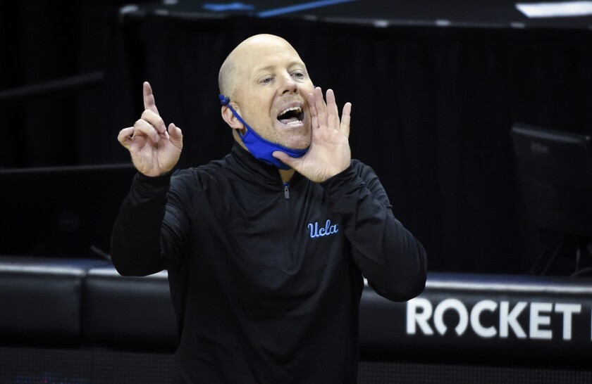 UCLA head coach Mick Cronin holds up a finger and calls to his team.