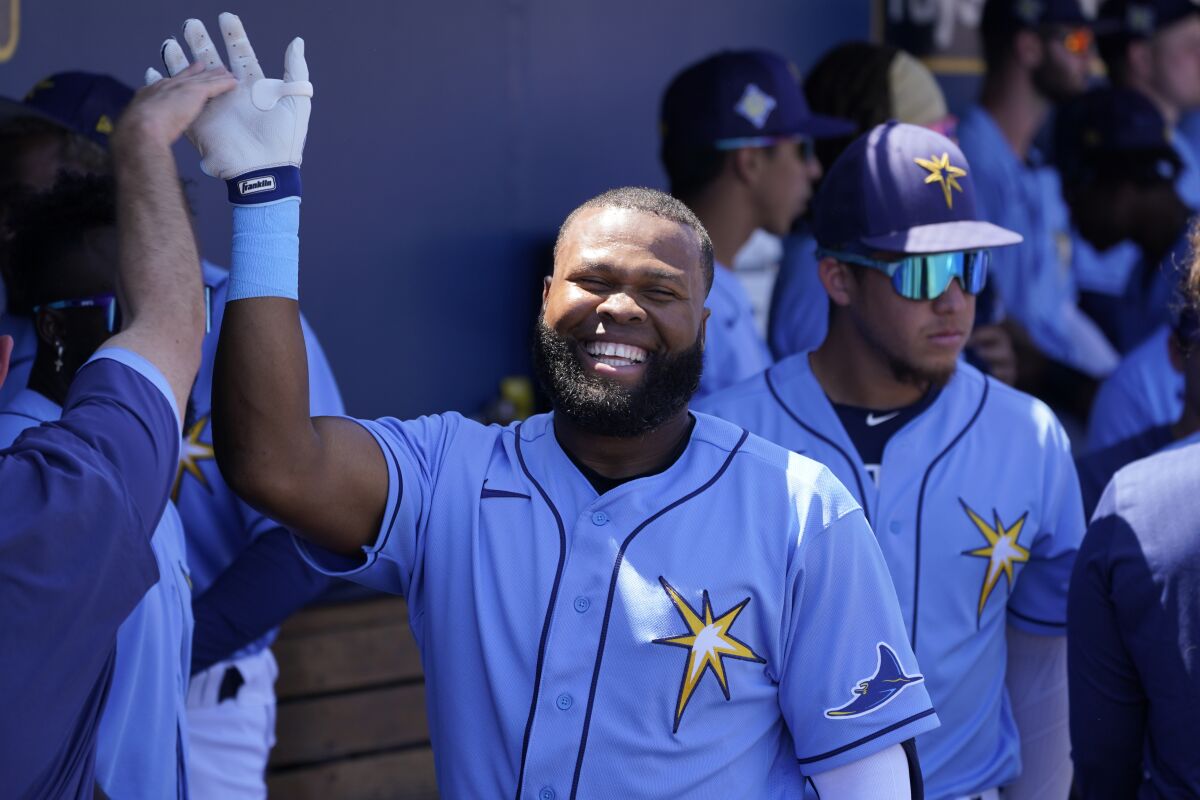 Tampa Bay Rays right fielder Manuel Margot (13) gets a welcome back to the dugout after a home run during a spring training baseball game against the Minnesota Twins at the Charlotte Sports Park Tuesday March 29, 2022, in Port Charlotte, Fla. (AP Photo/Steve Helber)
