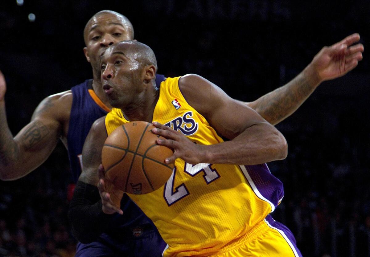 Lakers star Kobe Bryant drives to the basket before being fouled by P.J. Tucker during the first half of the Lakers' 114-108 loss Tuesday at Staples Center.