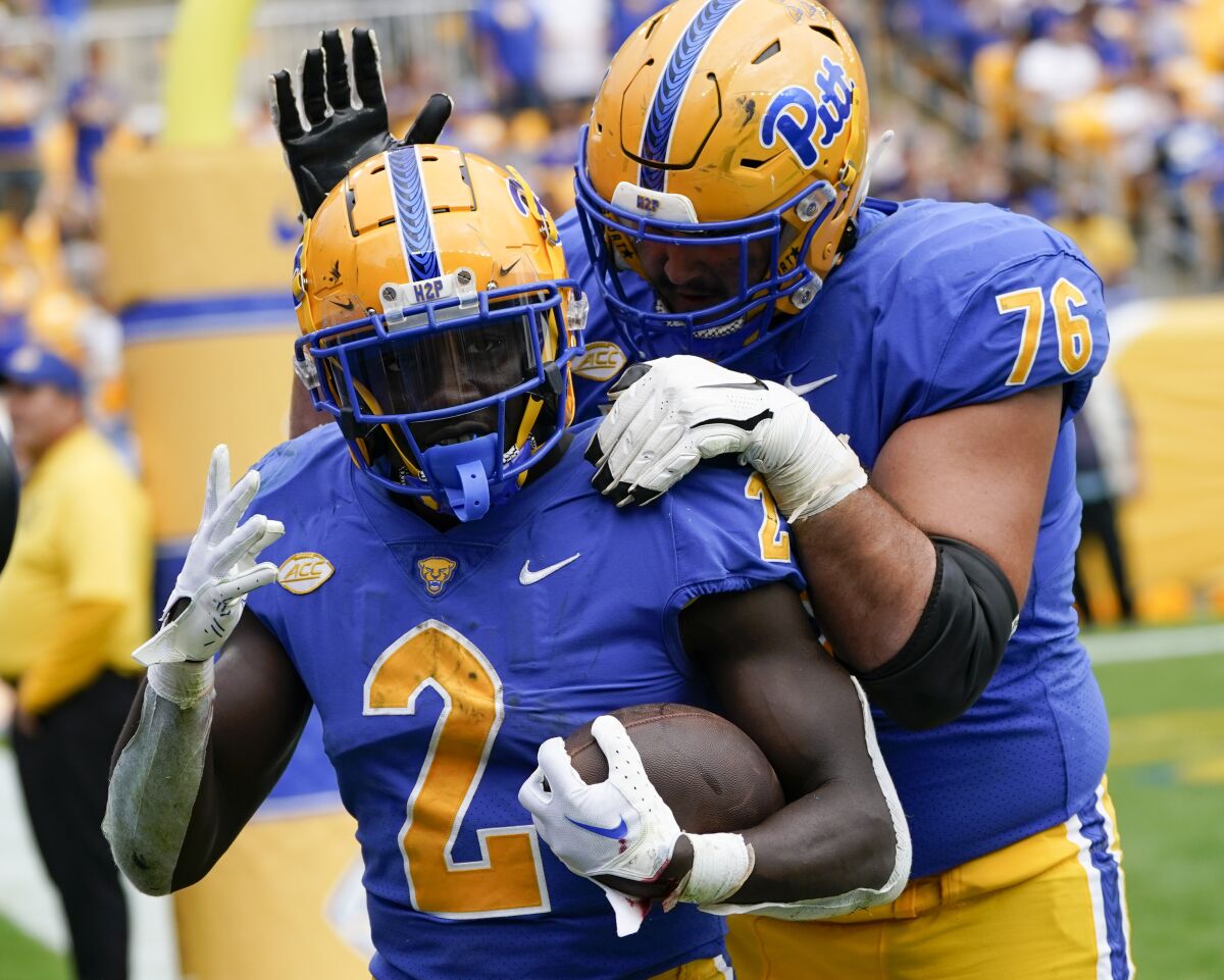 Pittsburgh offensive lineman Matt Goncalves (76) celebrates with running back Israel Abanikanda (2) after Abanikanda scored his fourth touchdown of the game during the second half of an NCAA college football game against Rhode Island, Saturday, Sept. 24, 2022, in Pittsburgh. Pittsburgh won 45-24. (AP Photo/Keith Srakocic)