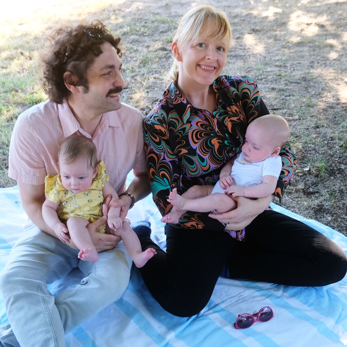 A man and a woman hold infants.