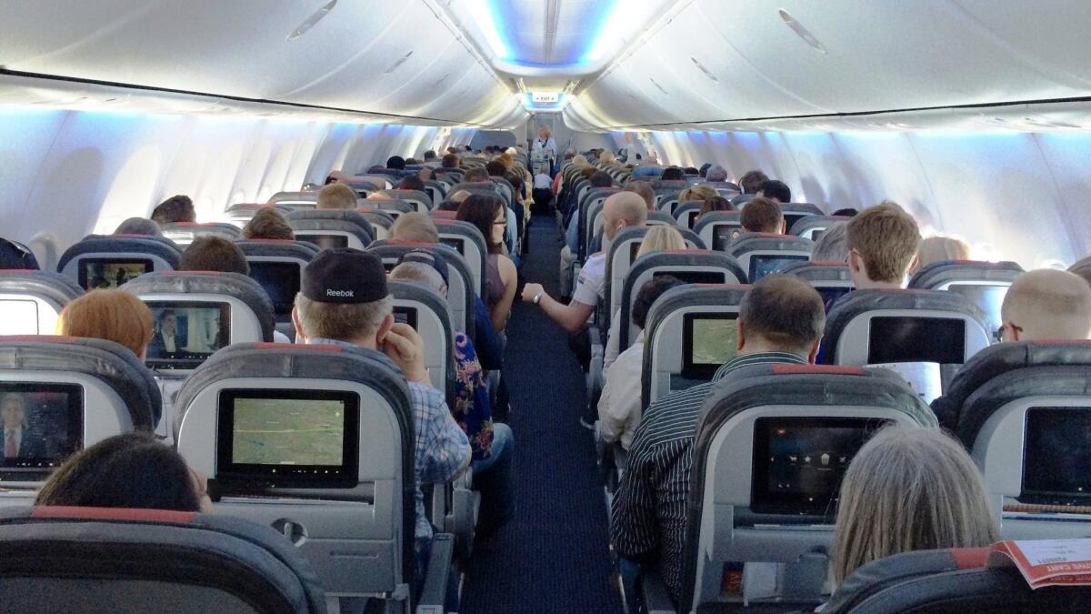 Passengers on an American Airlines 737 jet. The Federal Aviation Administration is required under a new bill to set minimum seat dimensions on airlines.