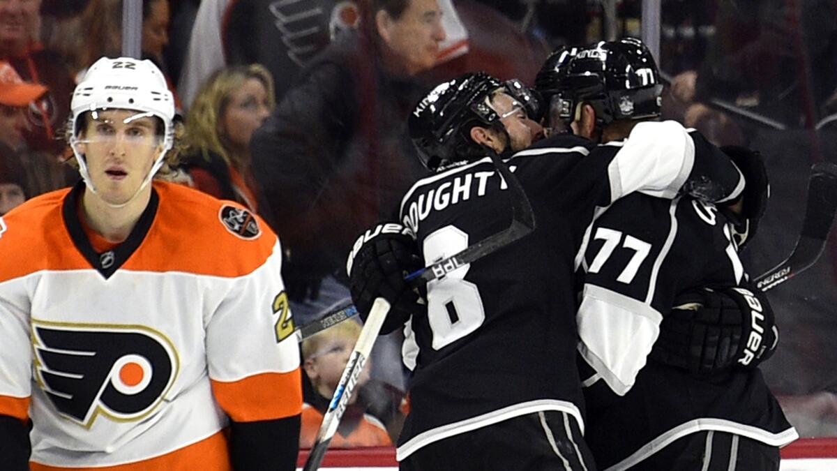 Kings center Jeff Carter (77) is congratulated by teammates Drew Doughty (8) and Anze Kopitar after scoring the winning goal against the Philadelphia Flyers and Dale Weise, left.