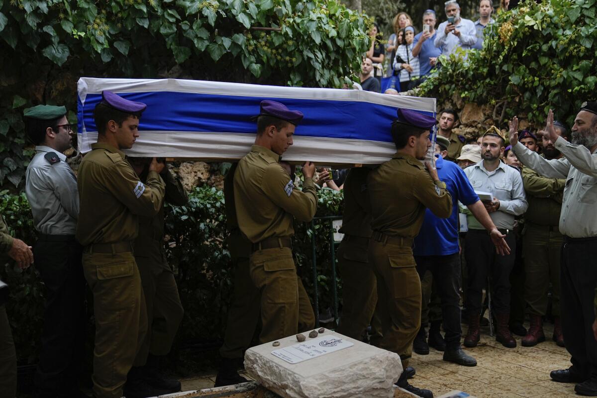 Israeli soldiers carry the flag-draped casket of a staff sergeant killed during a ground operation in the Gaza Strip.