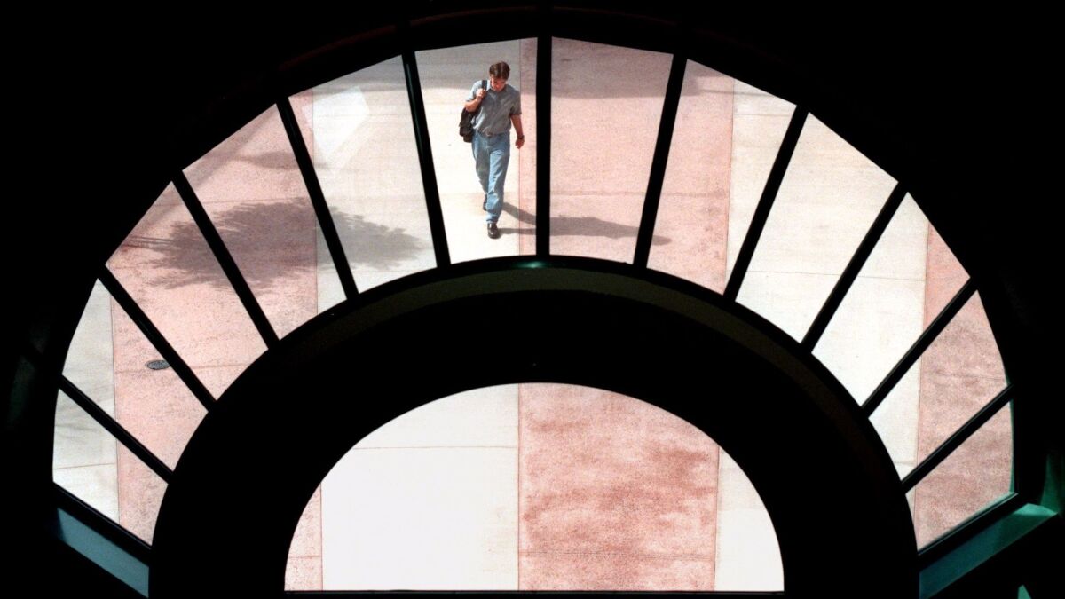 A student walking to class is framed by a large window in the new San Gabriel Building at Glendale Community College.