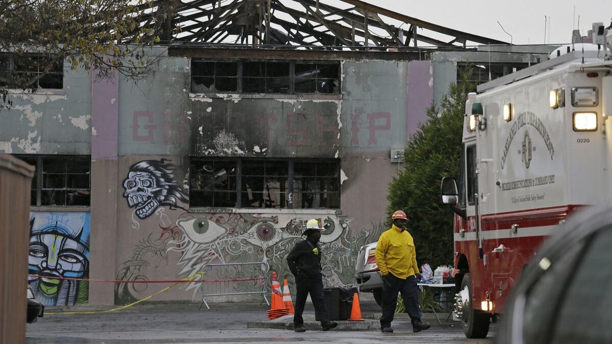 Oakland fire officials walk in 2016 past the remains of the Ghost Ship warehouse after a fire that killed 36 people.