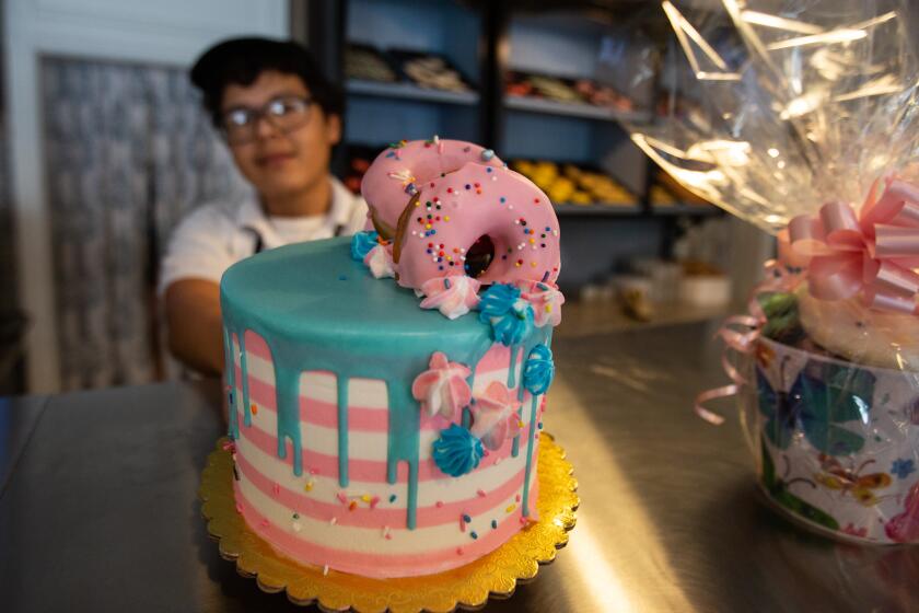 Torrance, CA., January 21, 2020 — Daniel Warren, 23, Torrance, shows a doughnut topped cake at Torrance Bakery on Tuesday, January 21, 2020 in Torrance, California. (Jason Armond / Los Angeles Times)