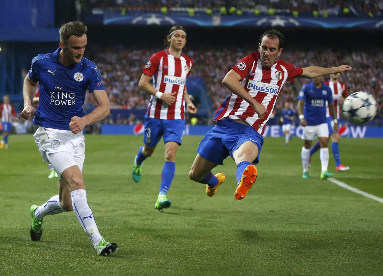 Leicester City's Andy King, left, hits a cross as Atletico's Koke attempts to block during the Champions League quarterfinal first leg soccer match between Atletico Madrid and Leicester City at the Vicente Calderon stadium in Madrid, Spain, Wednesday, April 12, 2017. (AP Photo/Paul White)