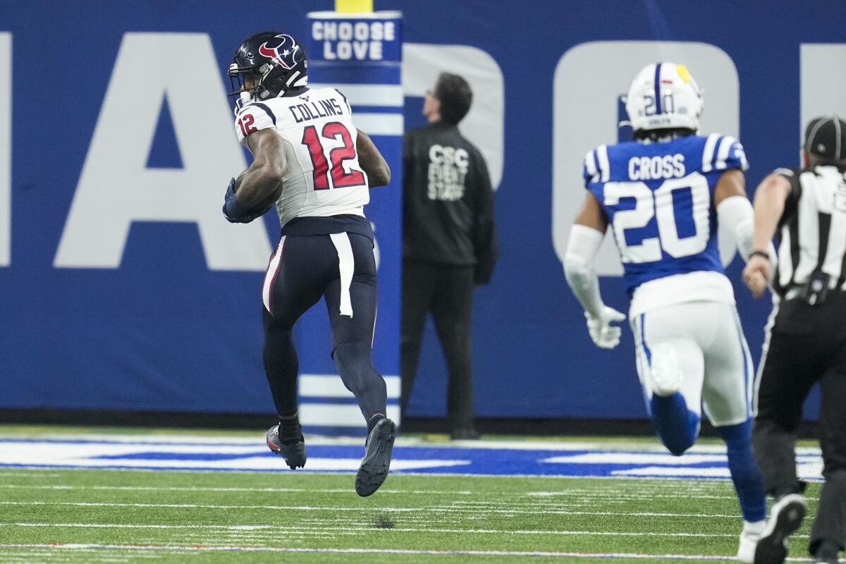 Houston Texans wide receiver Nico Collins (12) runs past Indianapolis Colts safety Nick Cross (20) to score a touchdown during the first half of an NFL football game Saturday, Jan. 6, 2024, in Indianapolis. (AP Photo/Michael Conroy)