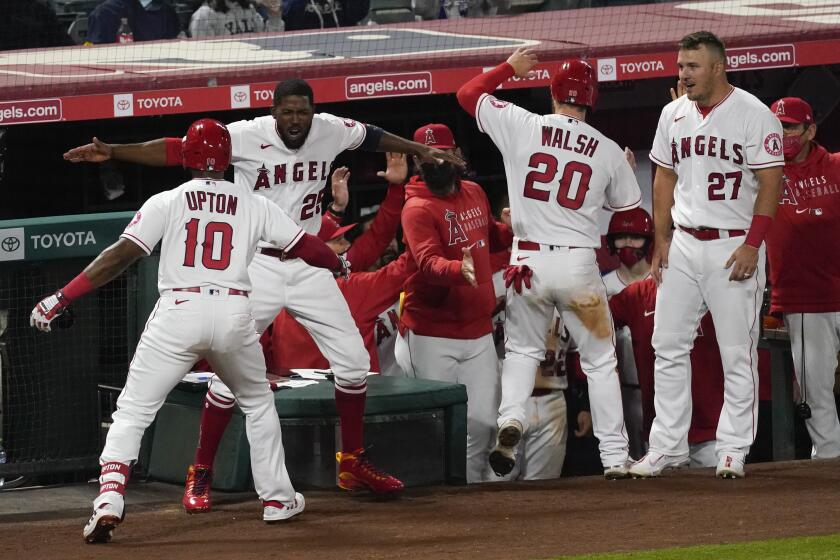 The Angels' Justin Upton (10) celebrates with teammates after he hit a go-ahead home run in the eighth inning April 3, 2021.