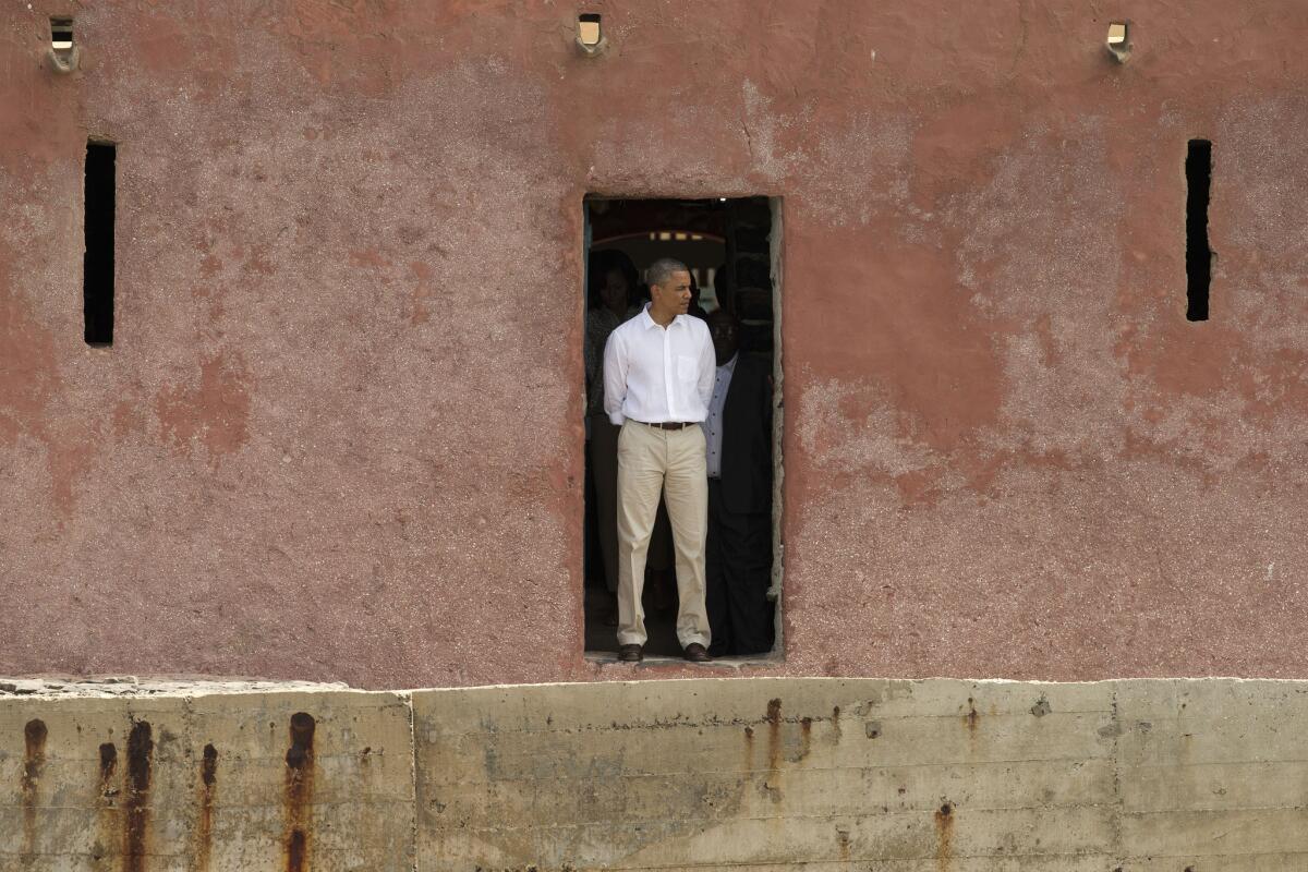 President Obama stands facing out to sea at the "Door of No Return" at a slave house on Goree Island in Dakar, Senegal, from which Africans were shipped across the Atlantic Ocean into slavery.
