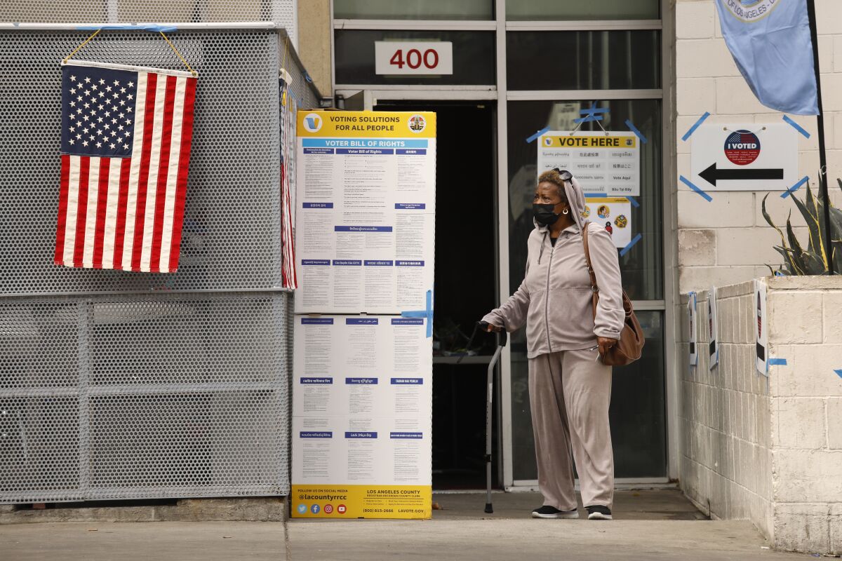 A woman who is living at the Union Rescue Mission casts her ballot at a community center.