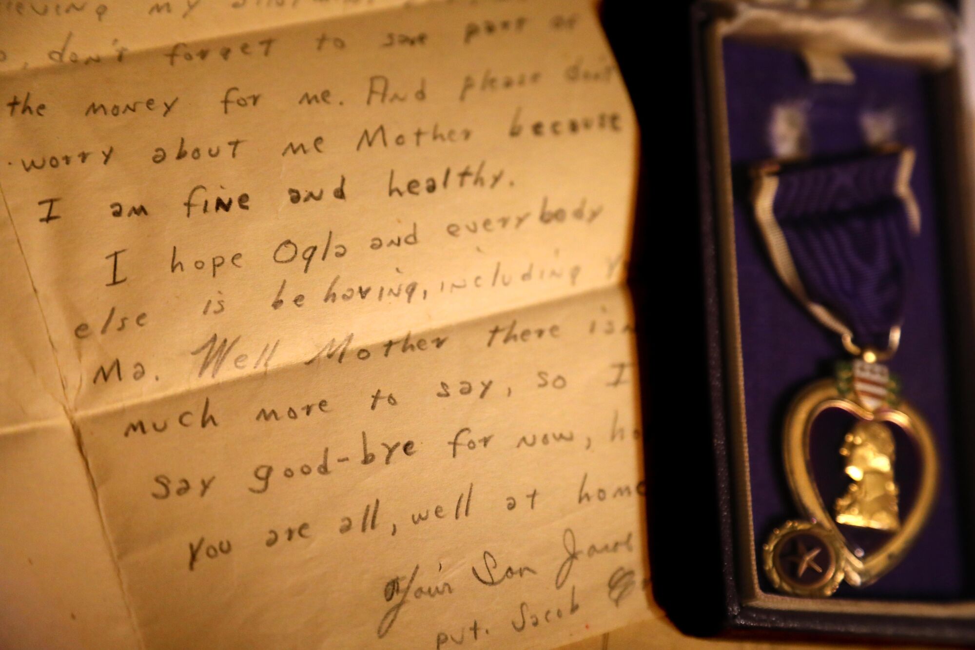 "I am fine and healthy," part of a letter states, shown next to a medal.