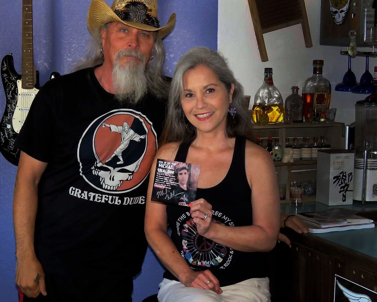 Billy and Kim Folsom pose next to each other near a bar area