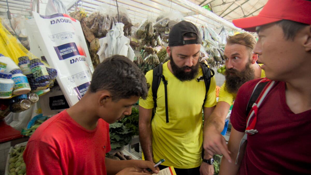 Riley McKibbin and his brother Maddison speak to a vendor.