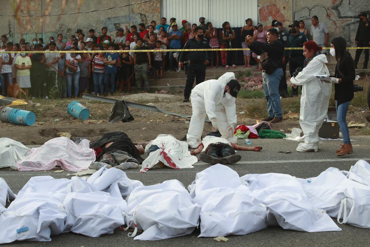 Los cuerpos en bolsas para cadáveres se colocan a un costado de la carretera después de un accidente en Tuxtla Gutiérrez