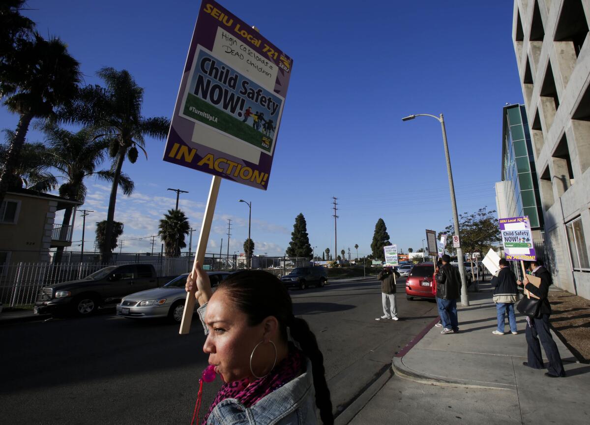 Brandie McMiller, an investigator with the Department of Children and Family Services, pickets outside DCFS offices on Vermont Avenue in South Los Angeles.