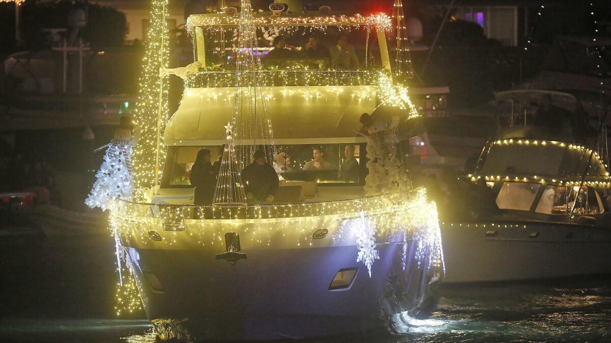 A large pleasure cruiser is draped in soft white light participates in the 110th Newport Beach Christmas Boat Parade on Wednesday.